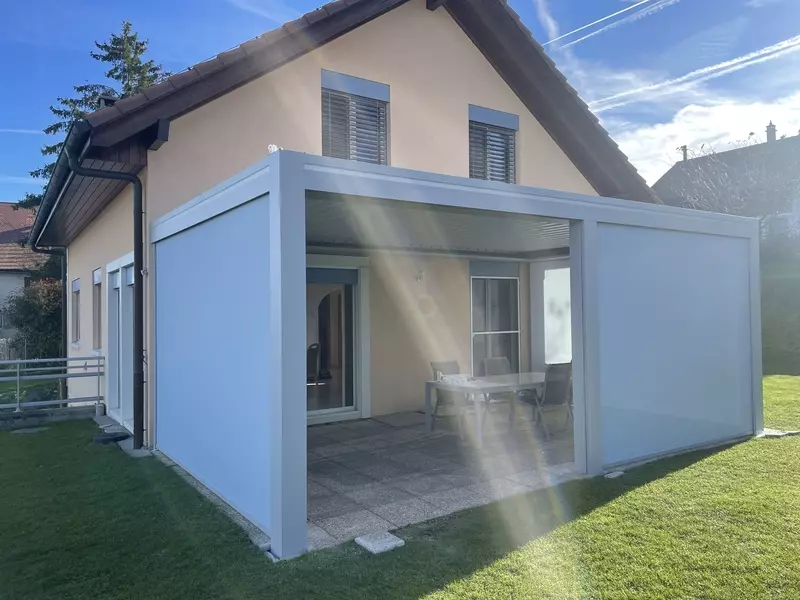pergola blanche avec stores en façade donnant sur pelouse