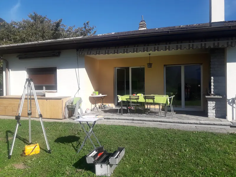 outil pour métré installé sur la pelouse devant une maison