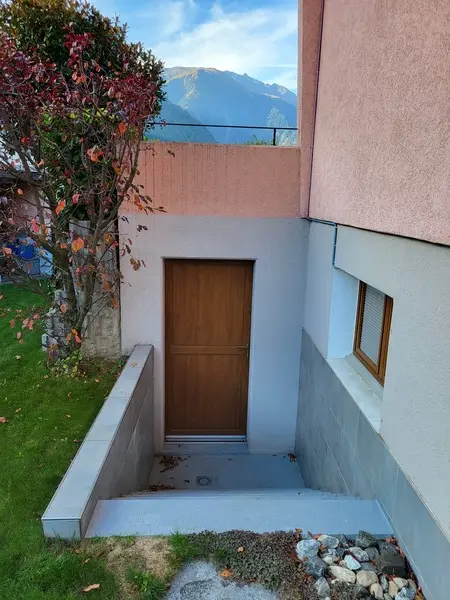 entrée en contrebas avec escaliers menant à la porte
